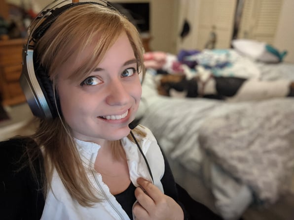 Chris in the foreground with headset with flonne on the bed in the background